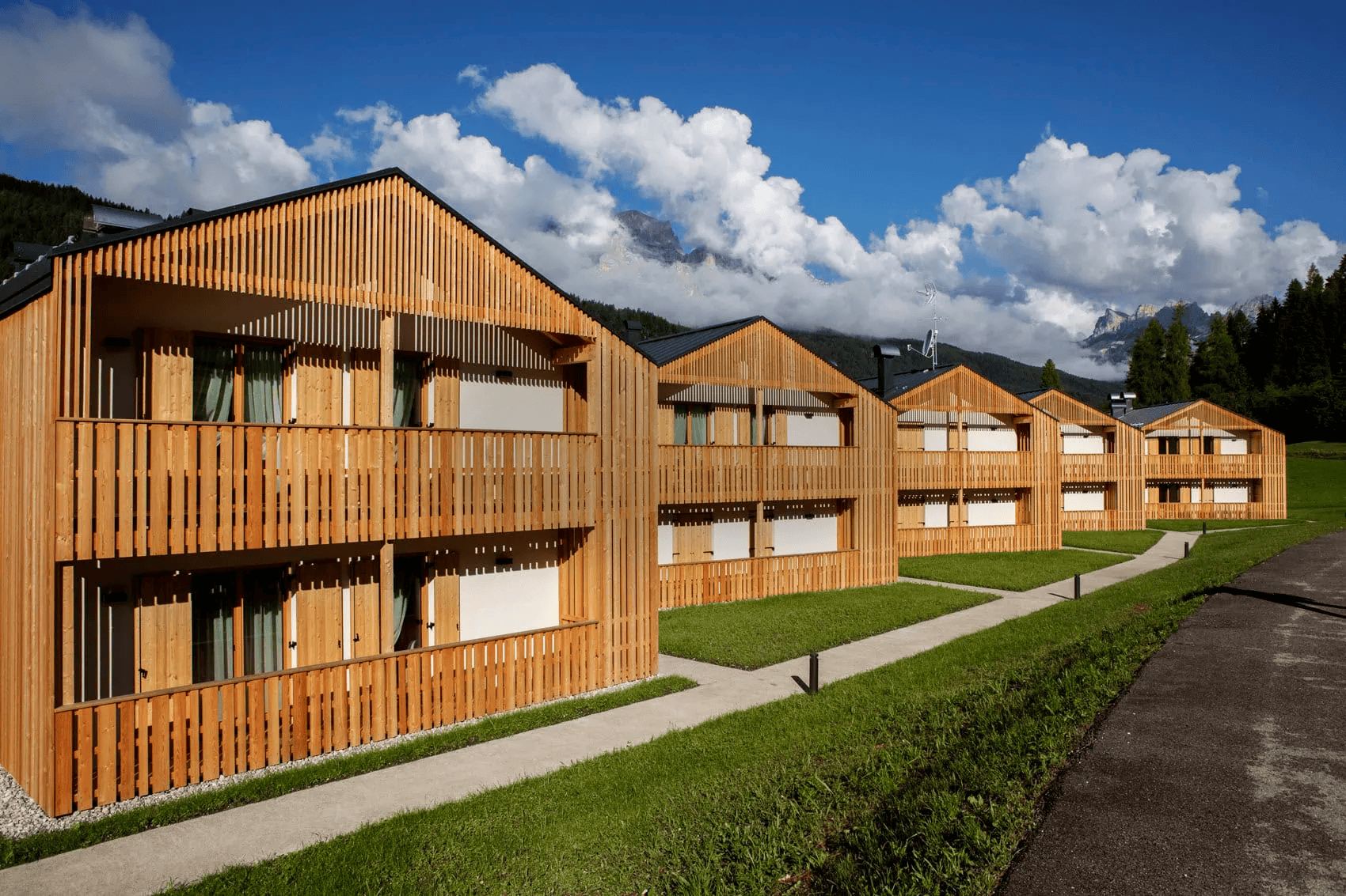 Contemporary wooden lodges at Al Capriolo with scenic mountain views.